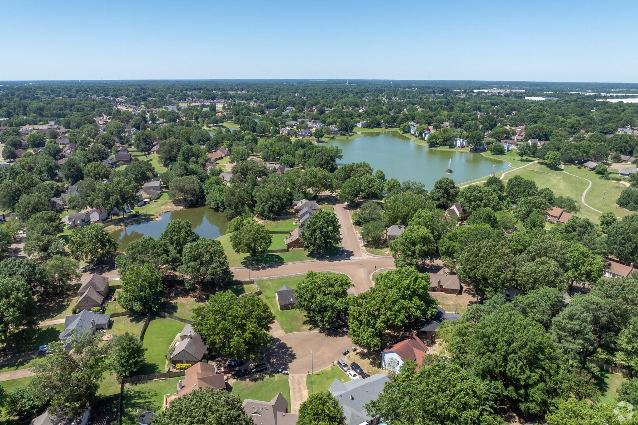 Aerial view of residential neighborhood in Germantown featuring tree-lined streets, single-family homes, and community lakes